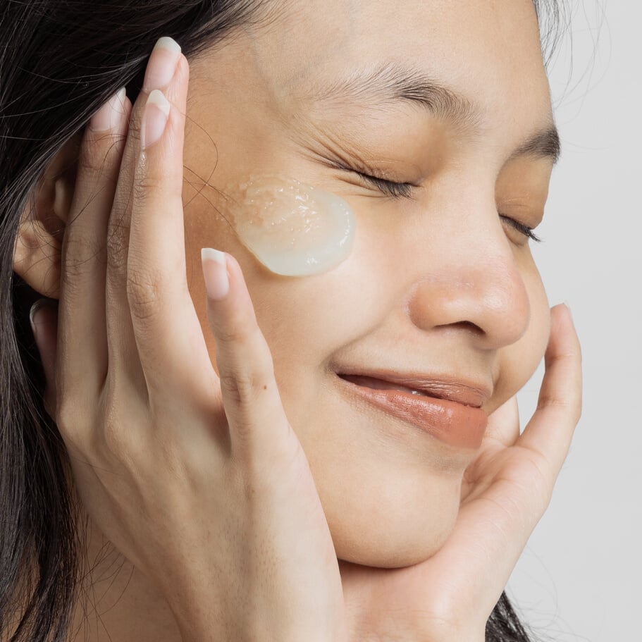 Closeup Portrait of Smiling Woman with Moisturizer